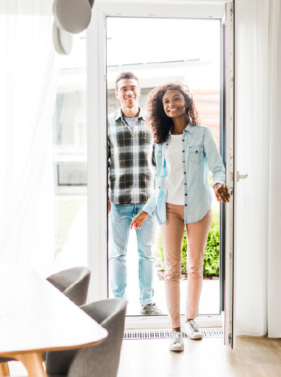 A couple opens a door of a house